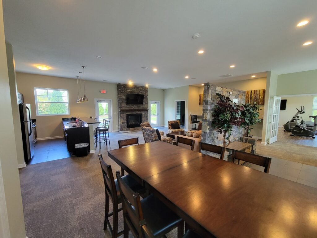 Open-concept clubhouse lounge with stone fireplace and kitchenette, Wexford PA