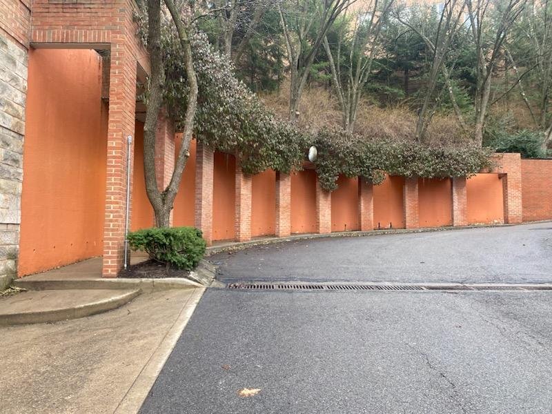 Exterior orange-coated concrete wall panels along a brick colonnade, Oakland Pittsburgh PA