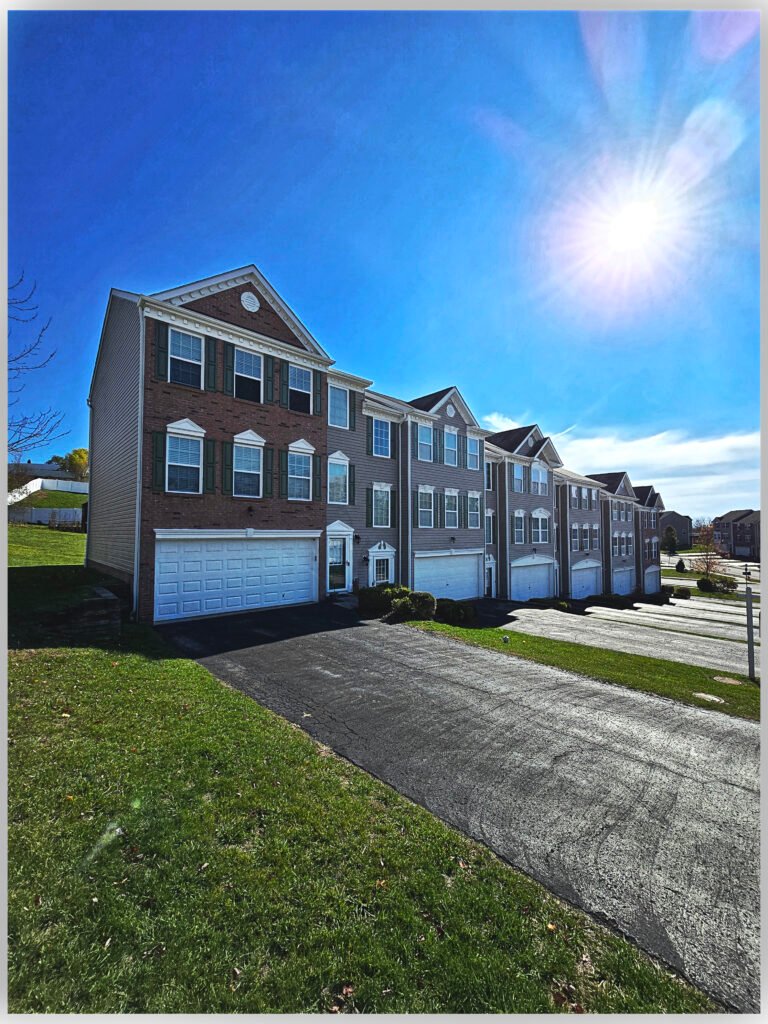 Brick and vinyl townhome exterior with white garage doors, Upper St. Clair PA