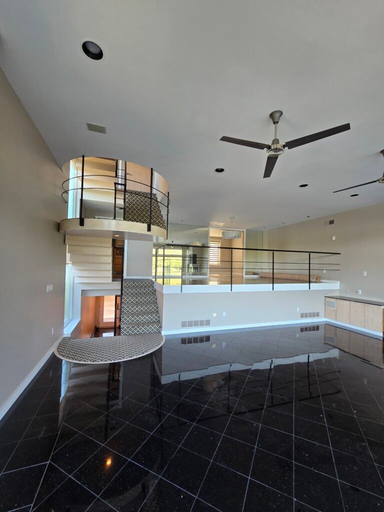 Two-story loft with spiral staircase and black tile floor, Fox Chapel PA